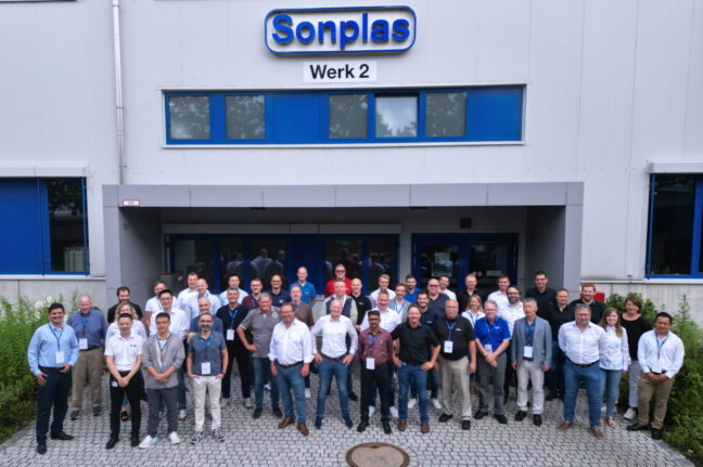 Eine Gruppe von knapp 50 Menschen seht vor dem Firmengebäude von Sonplas. Das Logo ist im Hintergrund zu sehen. Die Gruppe besteht aus Vertreterinnen und Vertretern von Sonplas sowie weltweiten Service- und Vertriebspartnern.